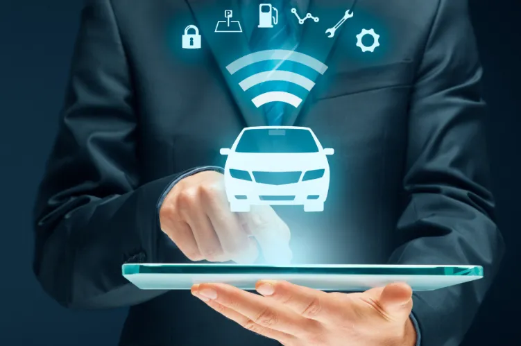 mężczyzna w garniturze z laptopem a nad nim cyfrowy wyświetlacz z samochodem 