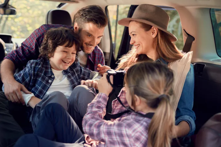 wesoła rodzina w samochodzie podczas podróży