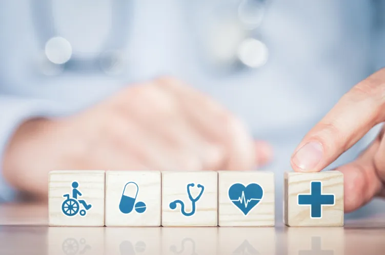 w tle lekarz, kostki z ikonami dotyczżcymi zdrowia 