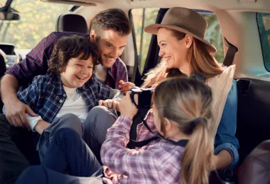 wesoła rodzina w samochodzie podczas podróży