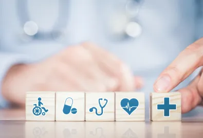 w tle lekarz, kostki z ikonami dotyczżcymi zdrowia 