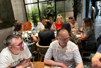 kolacja firmowa, ludzie siedzą, rozmawiają, jedzą 